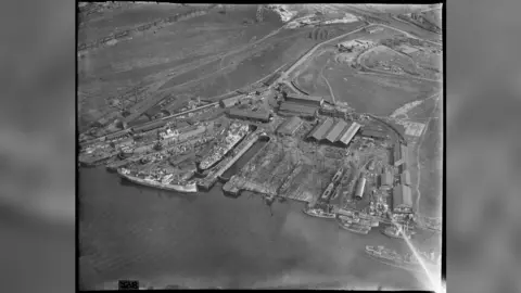 Historic England A black-and-white aerial shot of dockyards on a waterbody.