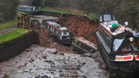 Two narrowboats at the bottom of a hole in a canal with no water