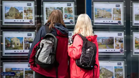 EPA-EFE/REX/Shutterstock Two women look at homes for sale at estate agents