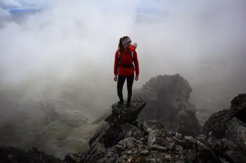 Anna Taylor/Mathew Wright Anna Taylor standing on the top of a rock