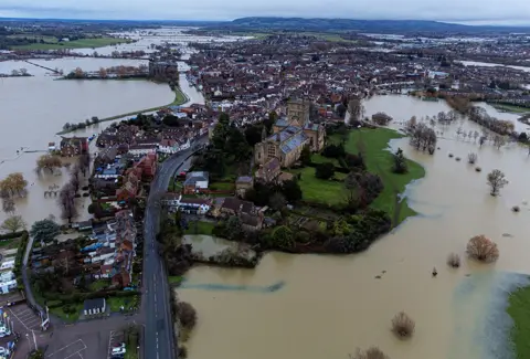 Ben Birchall / PA Media Flooding around Tewkesbury Abbey, in Gloucestershire, 14 January 2023