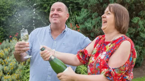 Camelot Alan and Claire Gray with champagne