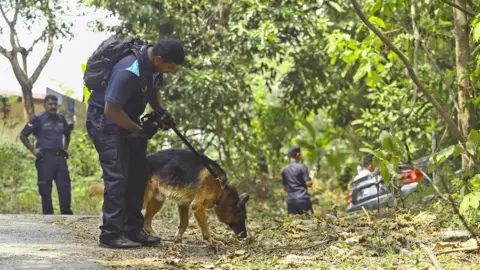 EPA/STR MALAYSIA OUT Police officer and dog searching