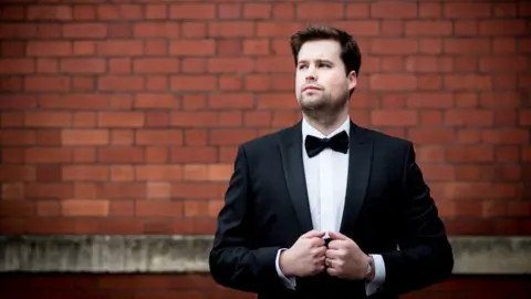 Sioned Birchall Adam in a suit for a promotional shot