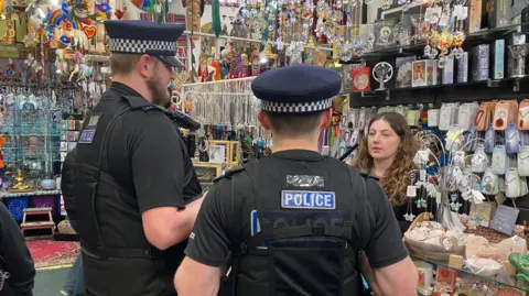 BBC/Amy Walker Kent Police officers speaking to a shop manager in Maidstone