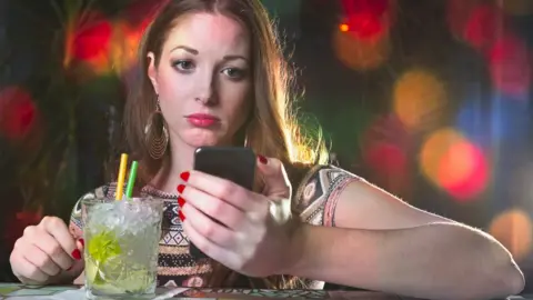 Getty Images Sad looking woman reading phone