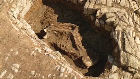BBC/Kevin Church Skeleton in medieval graveyard