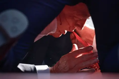 Anna Moneymaker/Getty Images Republican presidential candidate former President Donald Trump is shown covered by U.S. Secret Service agents after an incident during a rally in Butler, Pennsylvania