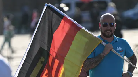 Getty Images Pendukung AfD memegang bendera Jerman