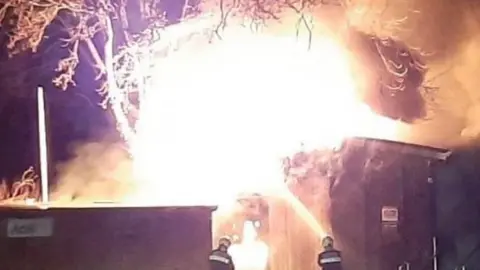 Debbie Miller-Wright Firefighters shoot water at blaze