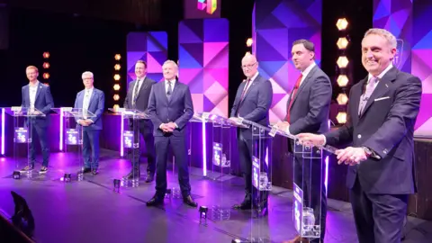 The party leaders at the debate, with host Stephen Jardine in the middle.