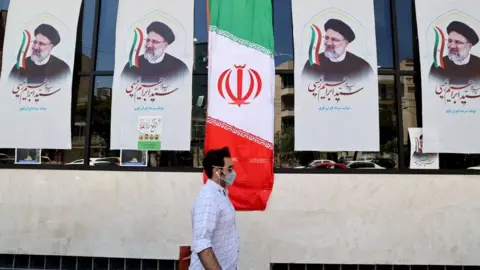 Getty Images A man walks past an Iranian flag