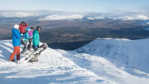 Steven McKenna Skiers and snowboards looking down Winger Wall at Nevis Range