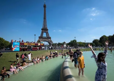 AFP People cool themselves at the Trocadero Fountain in front of The Eiffel Tower in Paris