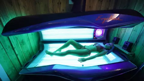 PA Media Eleassha Mcqueen, 18, takes to her first sunbed session in three months as Madame Tan opened today in Chirton, North Shields. PA Photo. Picture date: Monday July 13, 2020. Nail bars, beauty salons, tattoo and massage studios, physical therapy businesses, spas and piercing services are able to reopen in the latest lifting of restrictions in England.