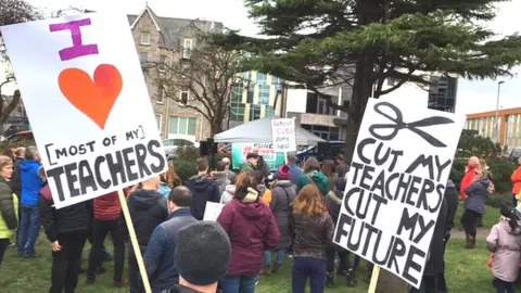 BBC Parents and pupils hold protest over planned education funding cuts in Conwy county