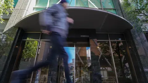 EPA A pedestrian runs past the building where Japan's Coincheck Inc company is located in Tokyo, Japan, 27 January 2018