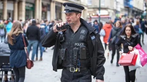 Francis Hawkins, SWNS.com Sergeant O'Loughlin on walkie talkie