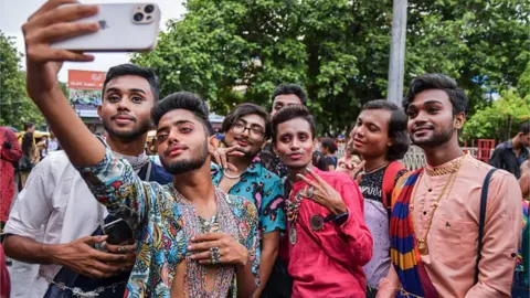 Getty Images Gender rights activists and supporters of the LGBTQ community take a selfie during the pride parade in Kolkata.