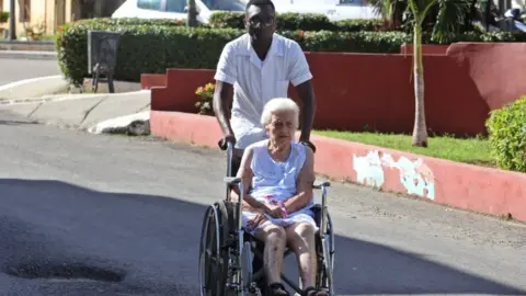 A health worker helps a lady in a wheelchair at the Calixto Garcia hospital in Havana, Cuba, on 14 November 2018