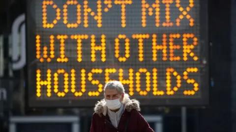 Reuters Woman in front of coronavirus sign