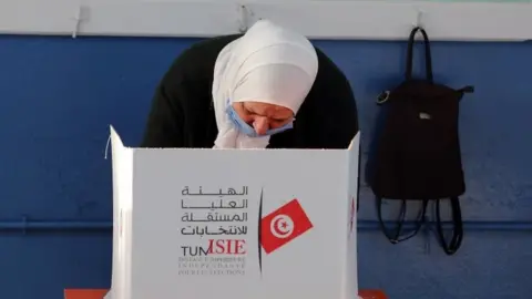 EPA A woman prepares to vote in Saturday's parliamentary elections in Tunisia. Photo: 17 December 2022