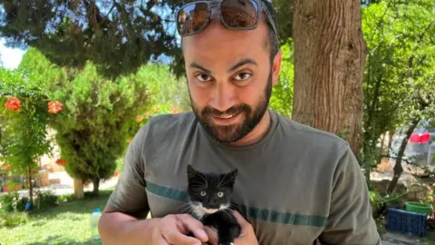 Reuters Reuters visuals journalist Issam Abdallah holds a kitten while posing for a picture in Saaideh, Lebanon