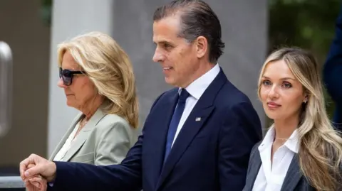 Hunter Biden holds the hand of Jill Biden, while Melissa Cohen Biden walks alongside them