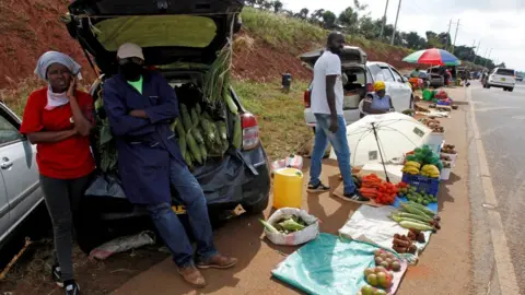 Reuters Motorists wait for customers next to their vehicles, used as alternative mobile grocery stalls along the highway, following a lockdown due to the coronavirus disease (COVID-19) outbreak, on the outskirts of Nairobi, Kenya May 25, 2020