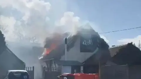 Fire and smoke on the roof of an Indian restaurant in daylight