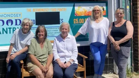 Five women stand in front of a food pantry store