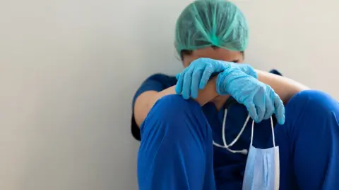 Getty Images Exhausted hospital worker