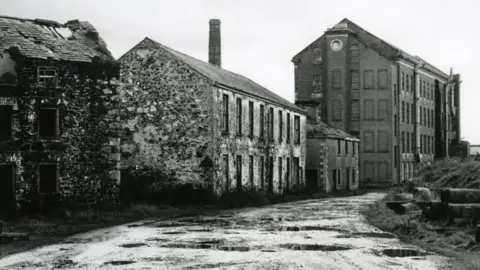 Ballymoney Museum Another angle of Balnamore Mill, showing potholes in road outside the building