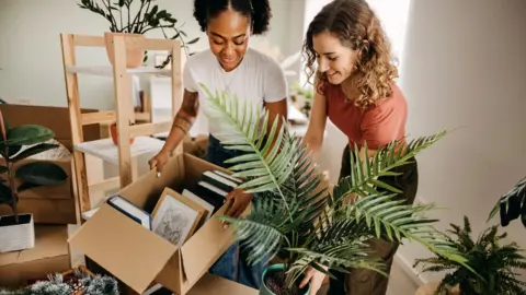 Getty Images Two young women unpacking boxes in a flat