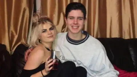 Esther Garrity A young woman and man sit on a sofa