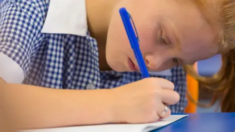 Getty Images Girl writing in class