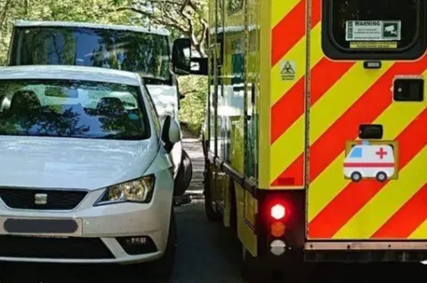 Cumbria Police Ambulance squeezes by car