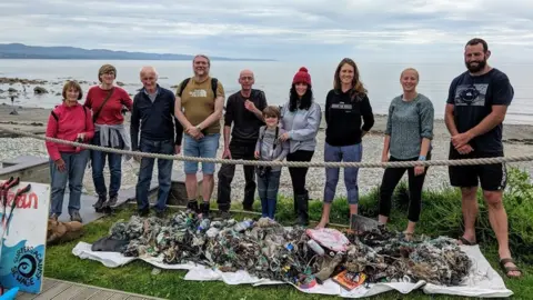 Kik-Plastic people standing over rubbish collected