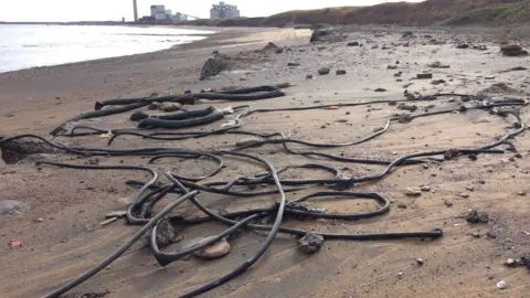 Steve Lowe Pipes and cables on the sand at Lynemouth Beach