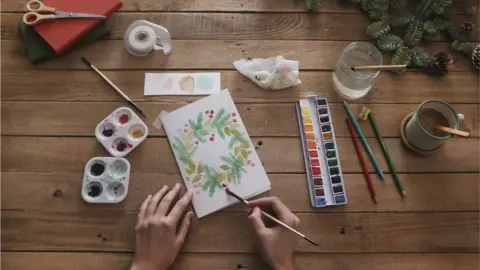 Getty Images Hand painting a Christmas card