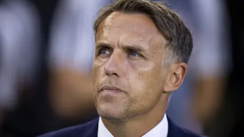 Phil Neville coaches on the sideline during an MLS match