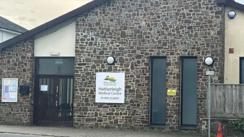 A brick building with a white sign saying Hatherleigh Medical Centre