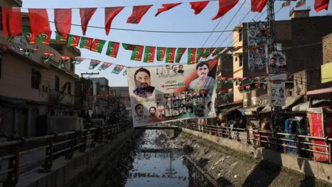 Reuters View of campaign posters and flags of political parties along a street, ahead of general elections, in Peshawar