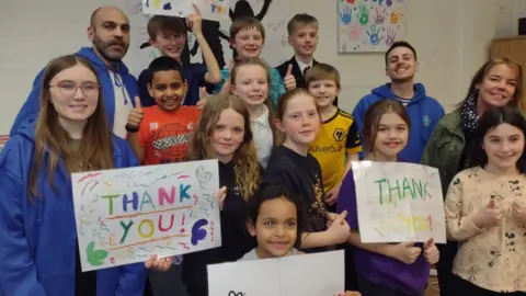 The Gap Children at the centre saying thanks for the money