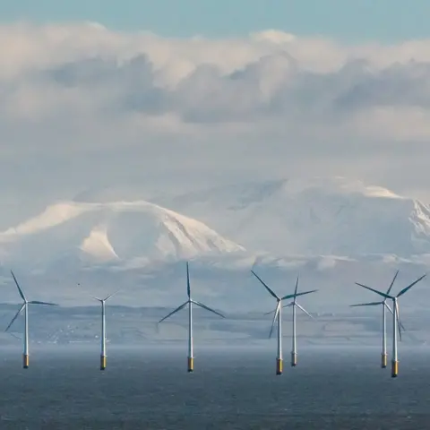 Quintin Lake Robin Rigg Wind Farm and the Cumbrian fells from Balcary Point, Dumfries and Galloway, Scotland.