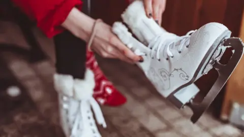 Getty Images Person putting on ice skates