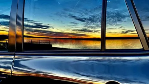 Sandy Neillands Sunset reflection on car