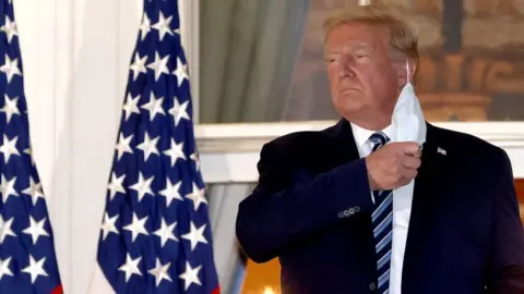 Getty Images Trump removing mask on White House balcony