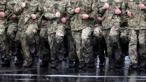 PA Media British soldiers marching in the rain