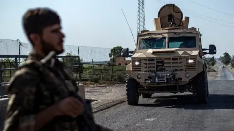 AFP File photo showing a fighter of the Syrian Democratic Forces (SDF) standing guard along a road in the town of al-Busayrah, in Syria's Deir al-Zour province, on 4 September 2023